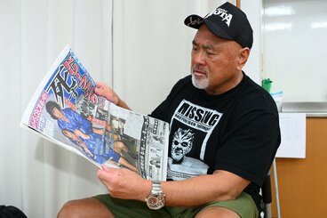 訃報を伝える紙面に目を落とす武藤敬司