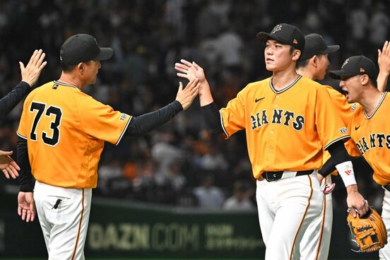 試合に勝利し選手を出迎える橋上秀樹監督代行（左）