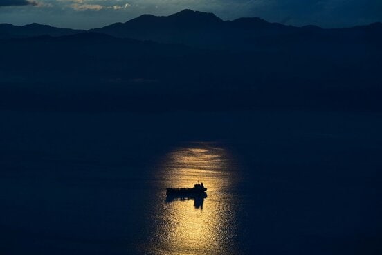 夕日に輝く水面と津軽海峡に浮かぶ船