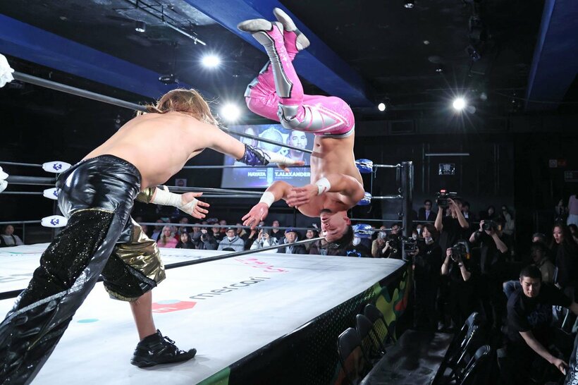 HAYATA(左)から場外のテーブルに投げつけられたタイタス・アレクサンダー