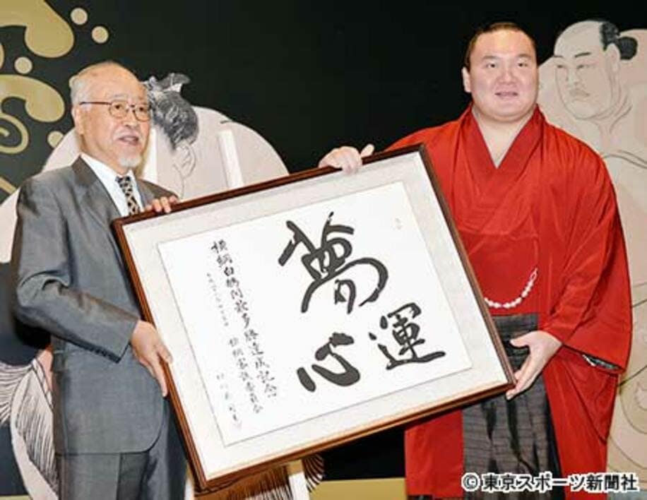  北村正任委員長（左）から記念額を贈呈された白鵬