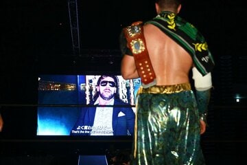ケニー・オメガからのメッセージを凝視するオスプレイ(右)