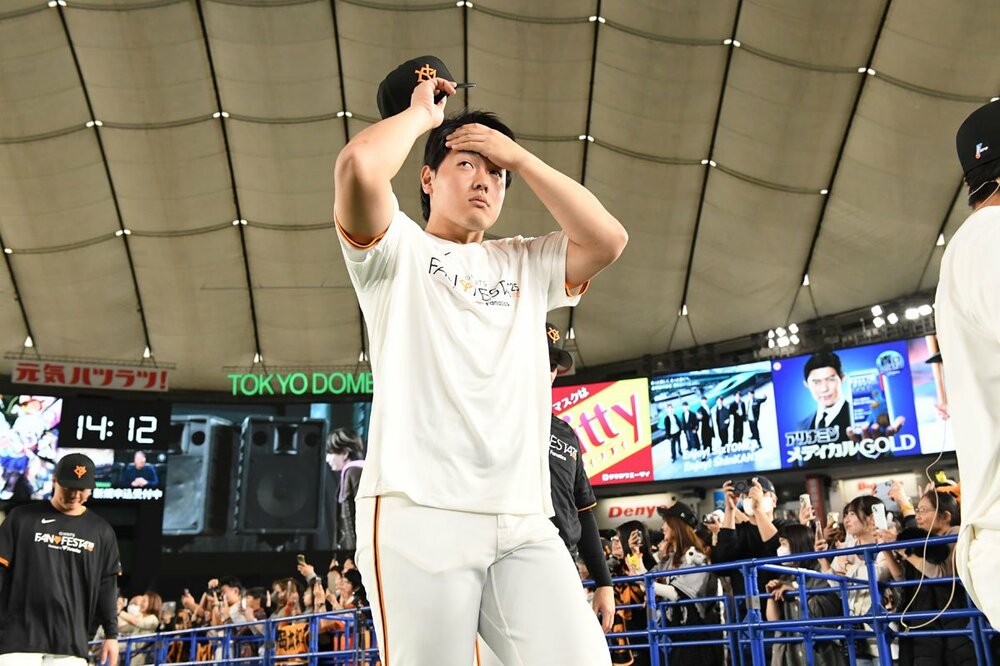 ファンに手を振りながら退場する岡本和真