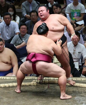 御嶽海(手前)に寄り切られ、悔しげな貴景勝