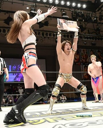  赤井沙希（左）の写真集を掲げた平田