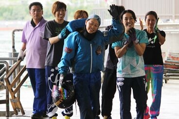 後輩レーサーたちの拍手に、手を挙げて応える寺田千恵(手前)
