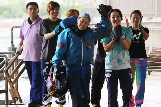 後輩レーサーたちの拍手に、手を挙げて応える寺田千恵(手前)