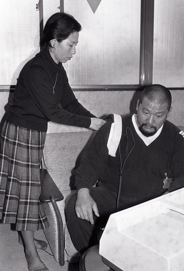 頸椎を負傷し自宅で電気治療する浜口。左は妻の初枝さん（１９８５年１１月、東京・浅草）