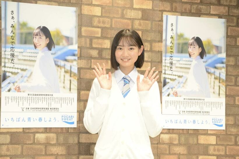 ポスターの前で手を振る近藤結良