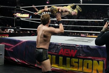 オカダ・カズチカ（手前）にトペ・スイシーダを浴びせるマスカラ・ドラダ　©All Elite Wrestling