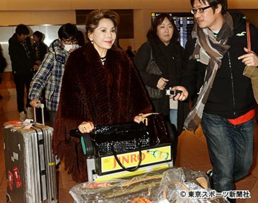帰国したデヴィ夫人は笑顔を見せるも、事件には無言だった