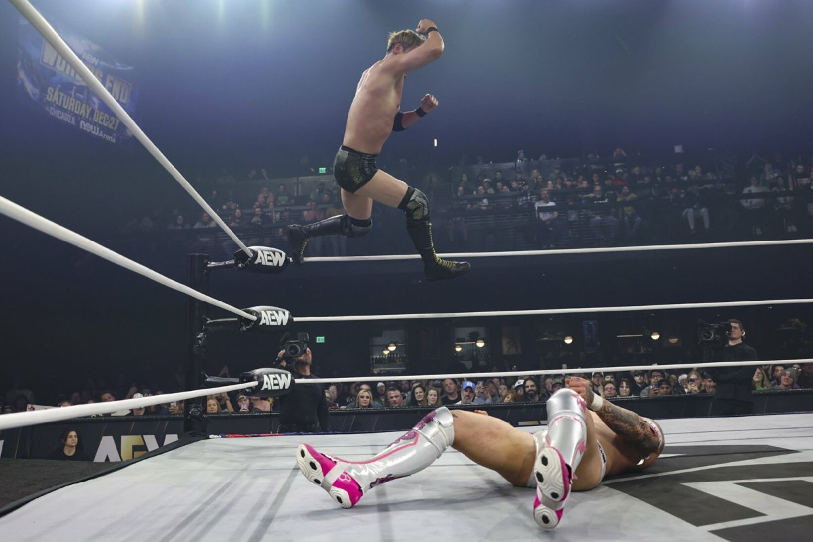 オカダ・カズチカ（上）はカイル・フレッチャーにダイビングエルボードロップを叩き込む（©All Elite Wrestling）