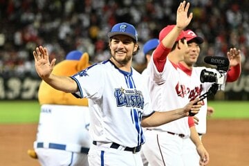 撮影しながら笑顔でファンの声援に応えるバウアー　