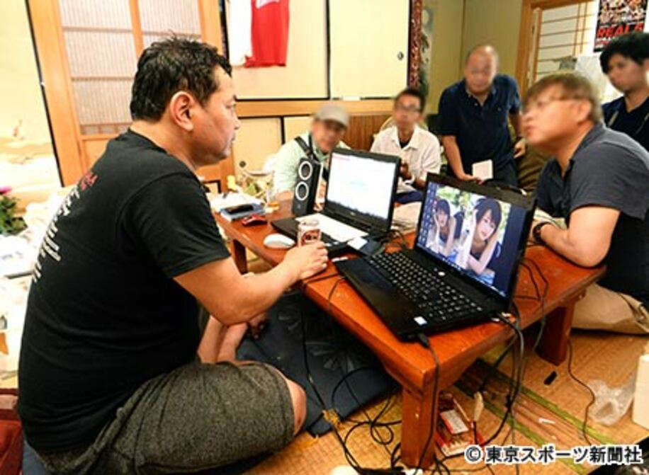 パソコン２台を前にして語る野村氏。右パソコンの画面壁紙は女優・吉瀬美智子の画像だった