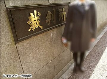 東京地裁の前に立つＳさん。一見すると普通の女性でオウムファンにはまったく見えない