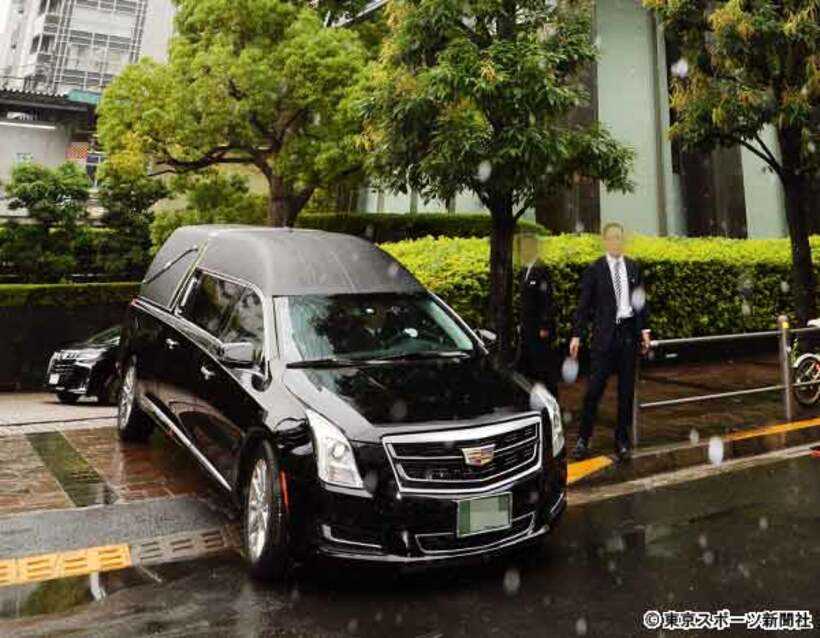  家族葬を終え、ビルを出る霊柩車