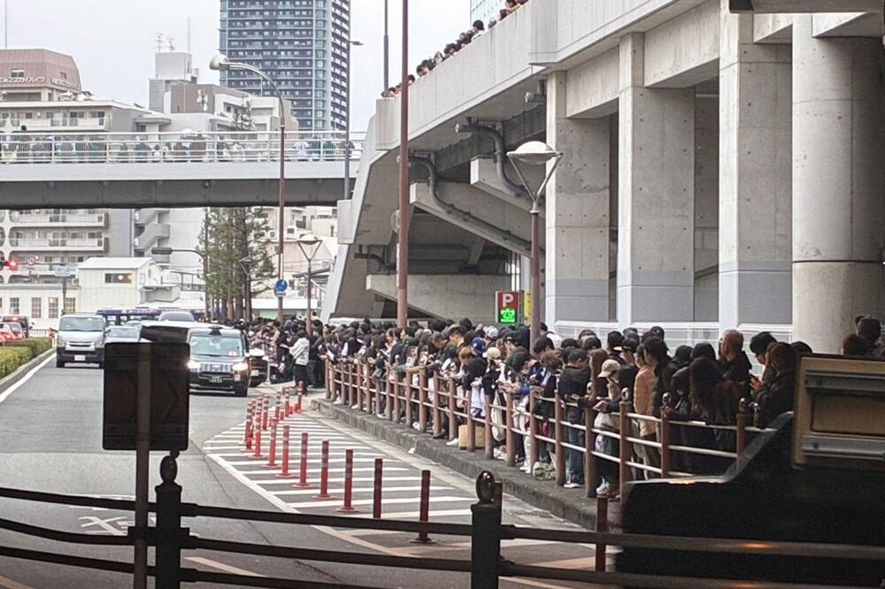 日本代表メンバーを乗せたバスをスタジアム外で待つファンら