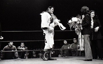 旗揚げ戦で柏木由紀子、倍賞千恵子(右)から花束贈呈される猪木を見つめる藤波(左端)。若き日のミスター・ポーゴの姿も…（1972年３月、大田区体育館）