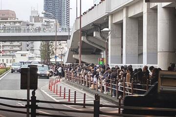 日本代表メンバーを乗せたバスをスタジアム外で待つファンら