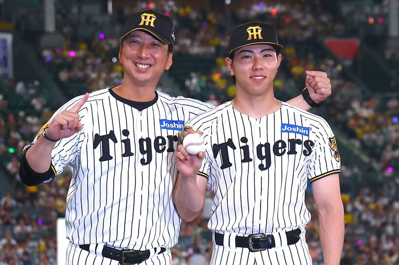 プロ初勝利を挙げ藤川球児監督（左）と記念撮影をする工藤泰成