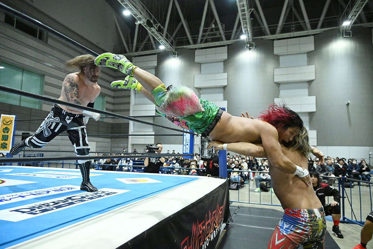 リング上のデビッド・フィンレー(左)から、場外の棚橋弘至(右)に投げつけられる高橋ヒロム