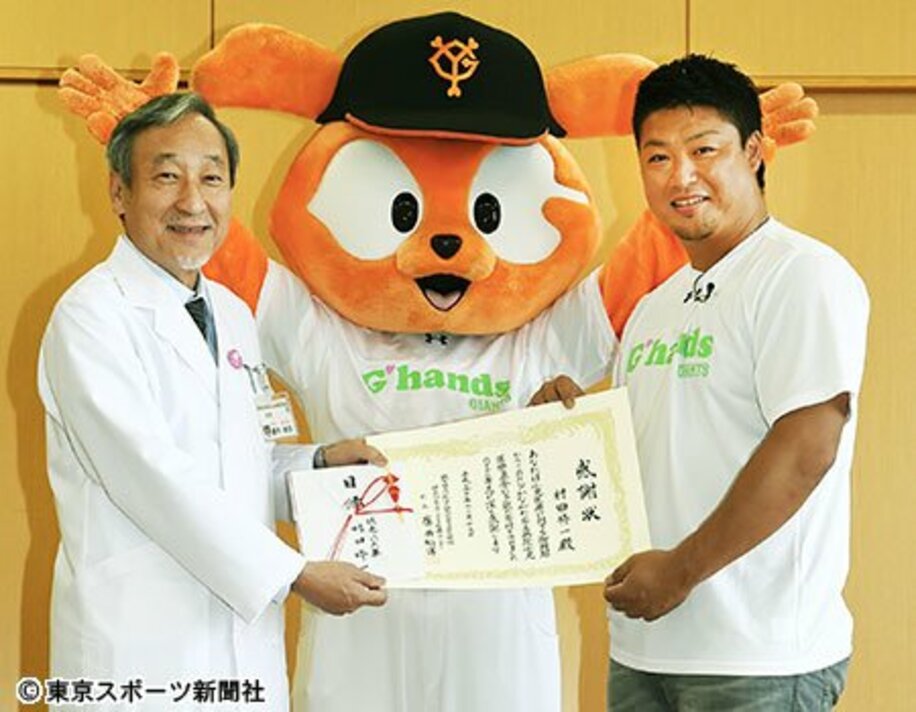 神奈川県立こども医療センターの康井総長（左）に寄付金を贈呈し、感謝状を贈られた村田