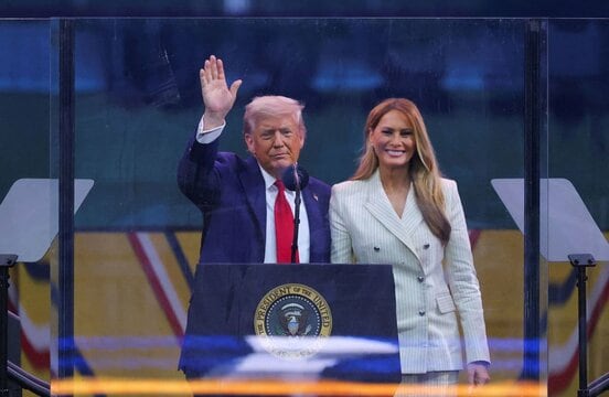 パレードの演説で聴衆に手を振るトランプ大統領。右はメラニア夫人(ロイター)