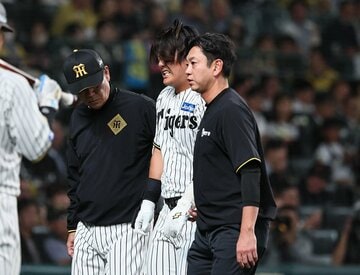 苦悶の表情でトレーナーらとベンチに下がる阪神・前川右京