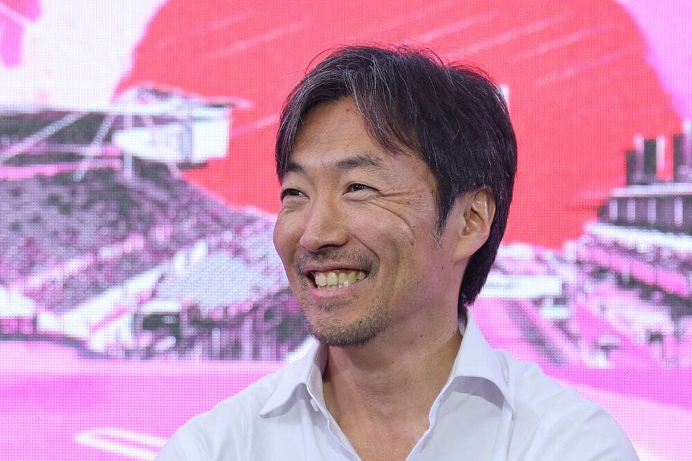 笑顔で質問に答える小松礼雄氏