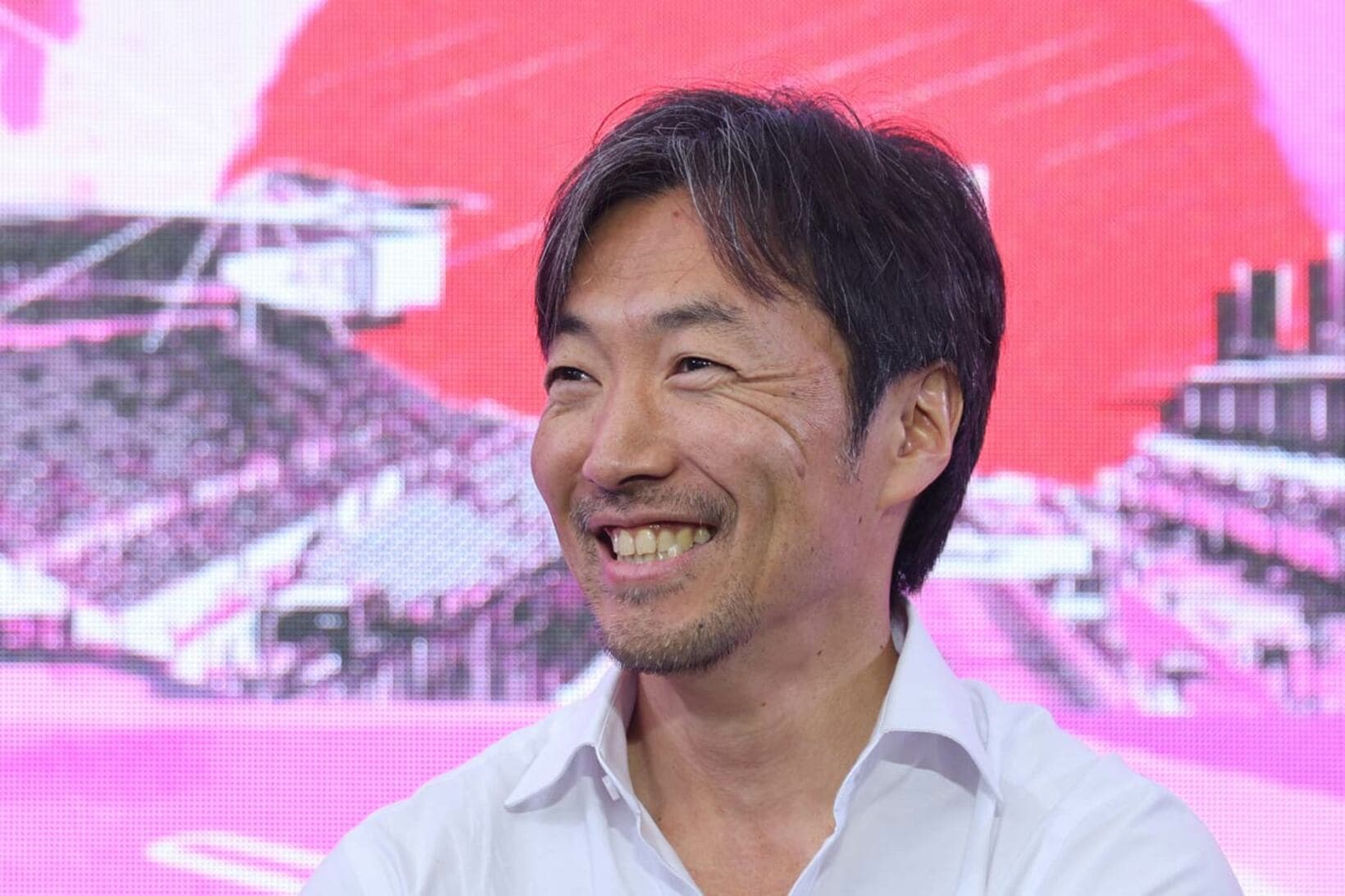 笑顔で質問に答える小松礼雄氏