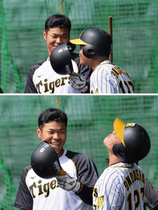  佐藤輝(左)のヘルメットのにおいをかぐ小野寺