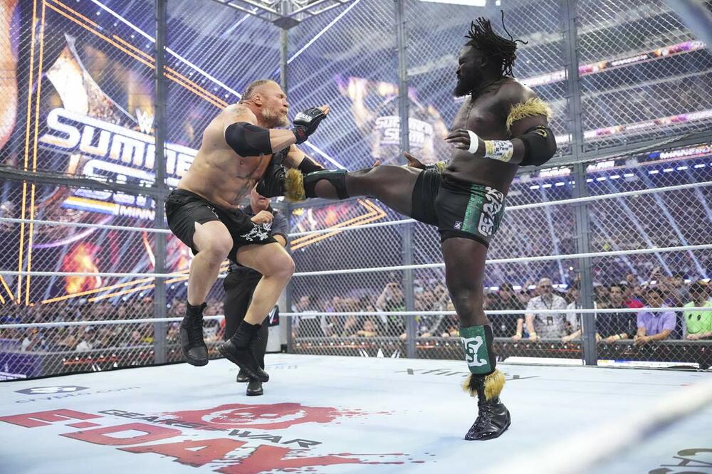 オバ・フェミ(右)はブロック・レスナーをキックで吹っ飛ばす(©WWE)