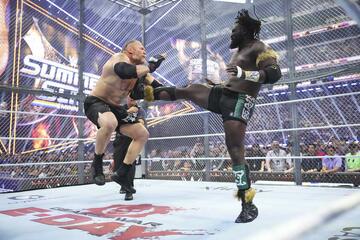 オバ・フェミ（右）はブロック・レスナーをキックで吹っ飛ばす（©WWE）