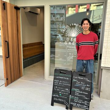 お店の前でニッコリ笑う田邉店長