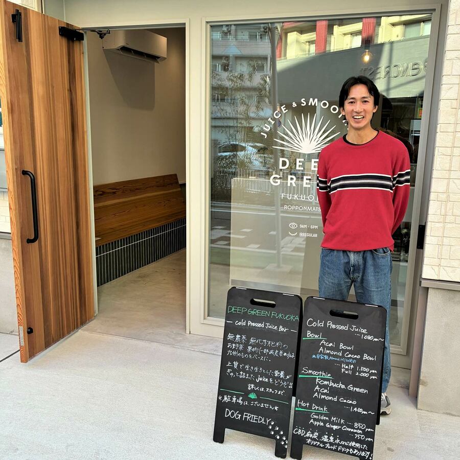 お店の前でニッコリ笑う田邉店長