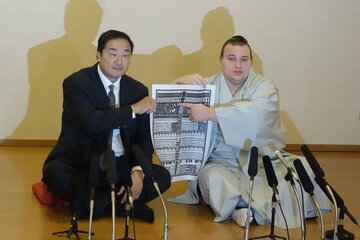 番付表のしこ名を指さす安青錦。左は安治川親方