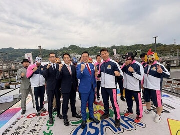 冨宅正浩市長（右から４人目）をはじめとする柏原市幹部とゼウスら大阪プロレスのレスラーたちはリング上でガッツポーズ（提供写真）