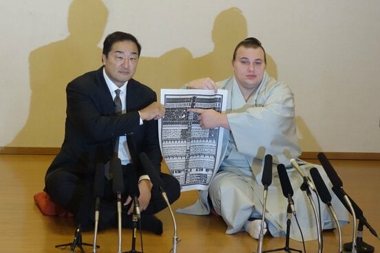 番付表のしこ名を指さす安青錦。左は安治川親方