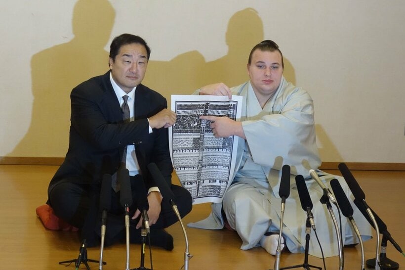 番付表のしこ名を指さす安青錦。左は安治川親方