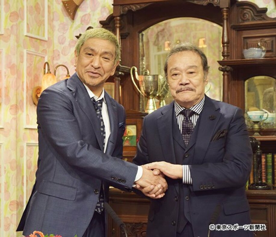  新局長の松本と握手する西田