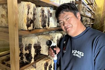 栽培しているきくらげに水をやる中原大樹さん