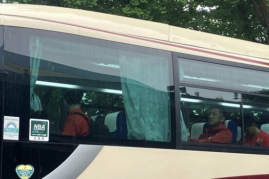 バスのカーテン（写真中央）に身を隠した広島・菊地原コーチ（後ろは永川投手コーチ）