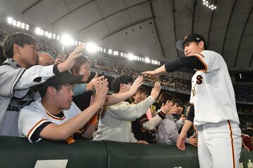 試合後、ファンとハイタッチする巨人・戸郷翔征(右)