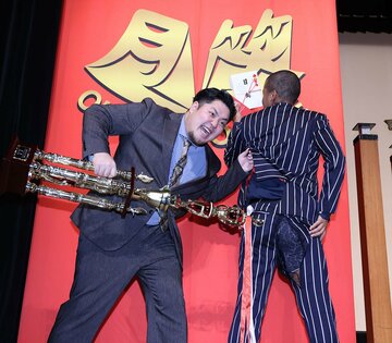 破けた衣装を披露するトミサット(右)