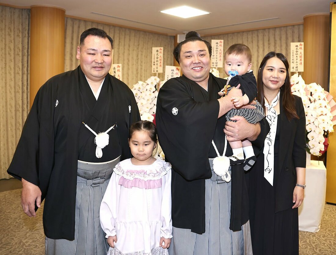 大関復帰会見でに、音羽山親方(左)と家族と記念撮影する霧島