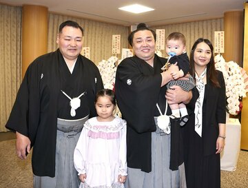 大関復帰会見でに、音羽山親方(左)と家族と記念撮影する霧島