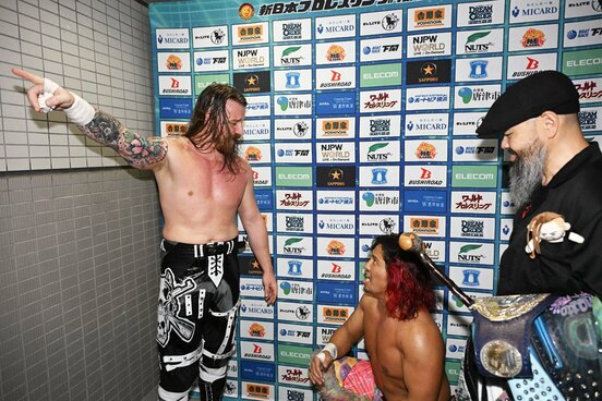 バックステージでのデビッド・フィンレー(左)と大モメの高橋ヒロム。右は外道