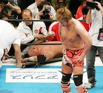 担架で運ばれる天山（奥）と顔を曇らせる小島（２００５年２月、両国国技館）