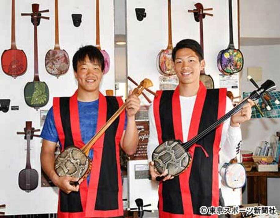 沖縄の伝統楽器・三線を体験した柳（左）と京田
