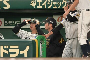 ９回、ベンチで渋い表情の阪神・藤川監督(左)